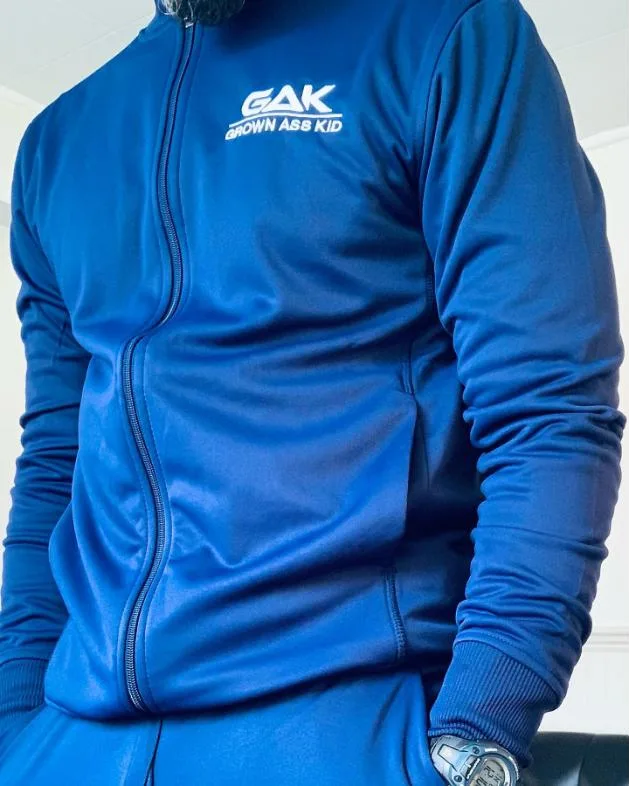 Blue GAK Grown Ass Kid zip track jacket worn by a model